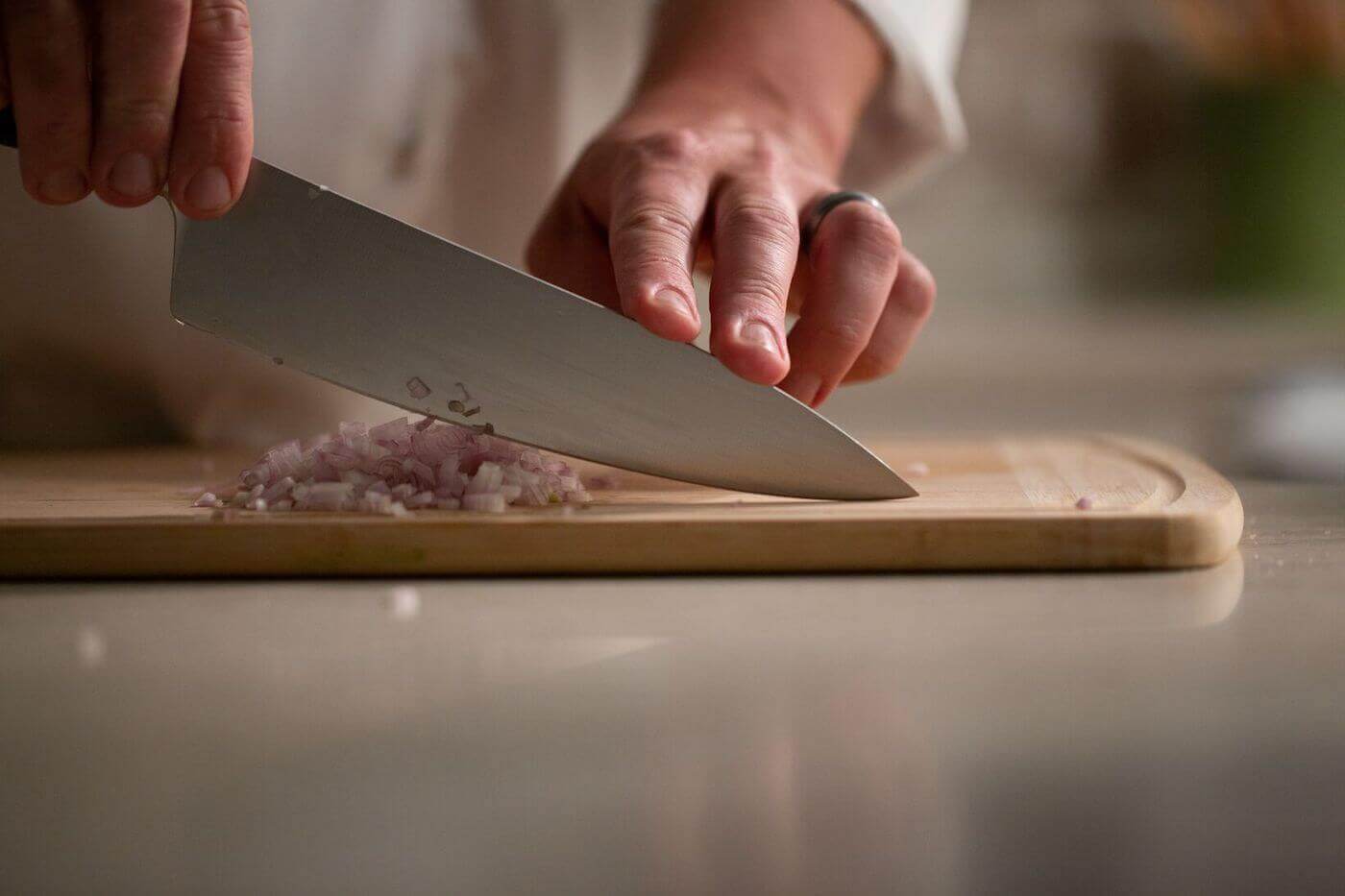 https://www.escoffier.edu/wp-content/uploads/2016/10/Chef-chopping-shallots-brunoise-style-on-a-wooden-cutting-board-1400.jpeg