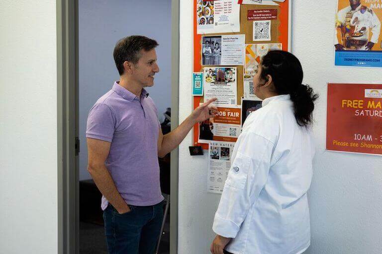 A Career Services staff person shows an Escoffier student a list of externship opportunities.