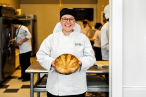  Etudiante en pâtisserie et pâtisserie Escoffier tenant du pain cuit au four 