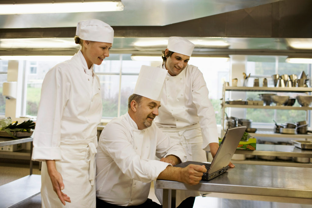  Trois chefs regardant un ordinateur portable 