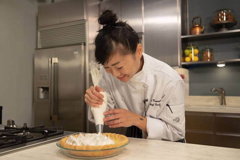 Escoffier Baking and Pastry Chef Instructor Erin Kanagay-Loux uses a piping bag to add meringue to a pie shell.