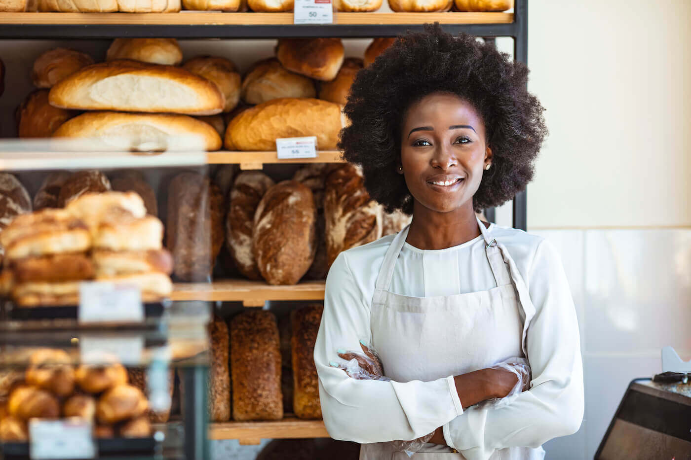 https://www.escoffier.edu/wp-content/uploads/2023/01/Baker-wearing-a-white-apron-standing-in-front-of-fresh-bread-with-arms-crossed-1400.jpeg