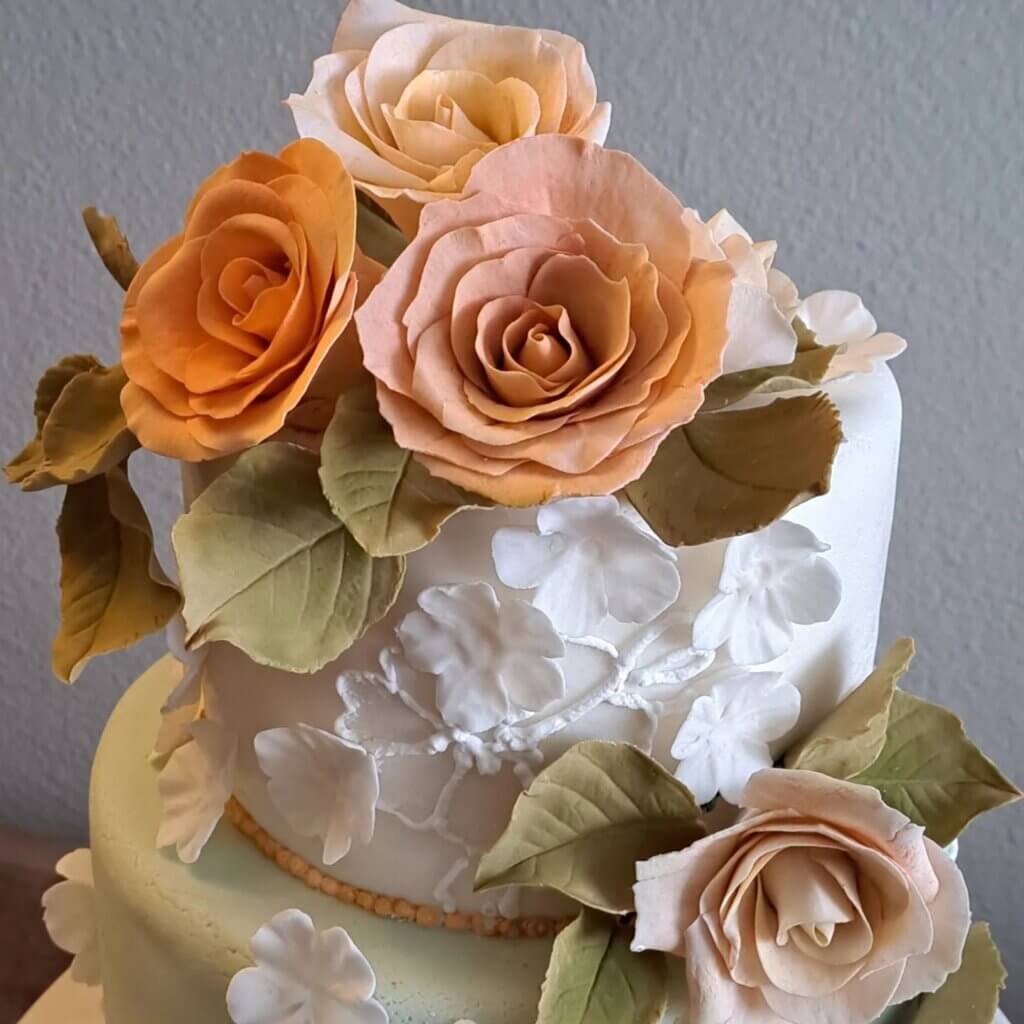 A two-tiers fondant cake covered in colorful fondant flowers