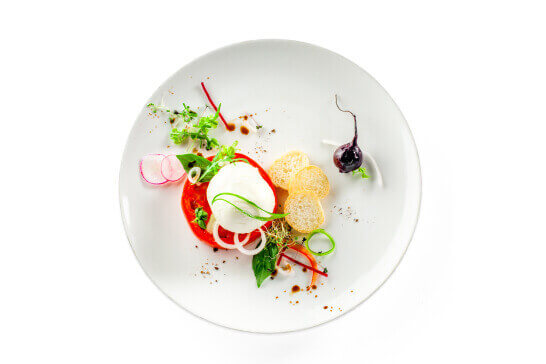 A caprese salad with burrata radishes and fresh tomato