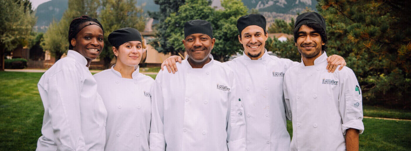 A group of Escoffier Boulder campus students standing outside smiling at the camera