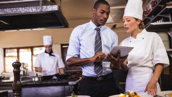 A restaurant manager talks to the head chef about the new menu