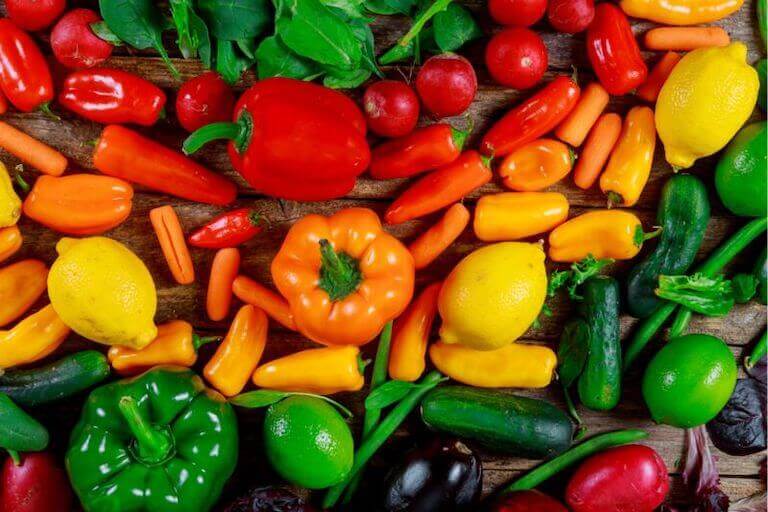 A display of brightly colored bell peppers, cucumbers, tomatoes, and eggplant showcases fruits that we usually think of as vegetables.