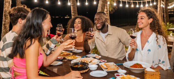 A group of smiling diners celebrating at an outdoor restaurant