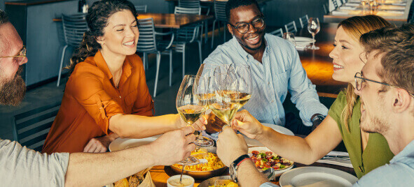 A group of diners toasts with wine in a restaurant