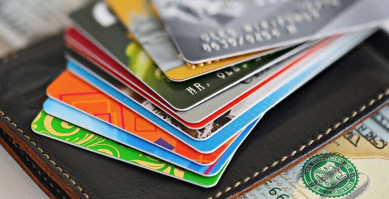 A closeup of credit cards sitting on top of a wallet.