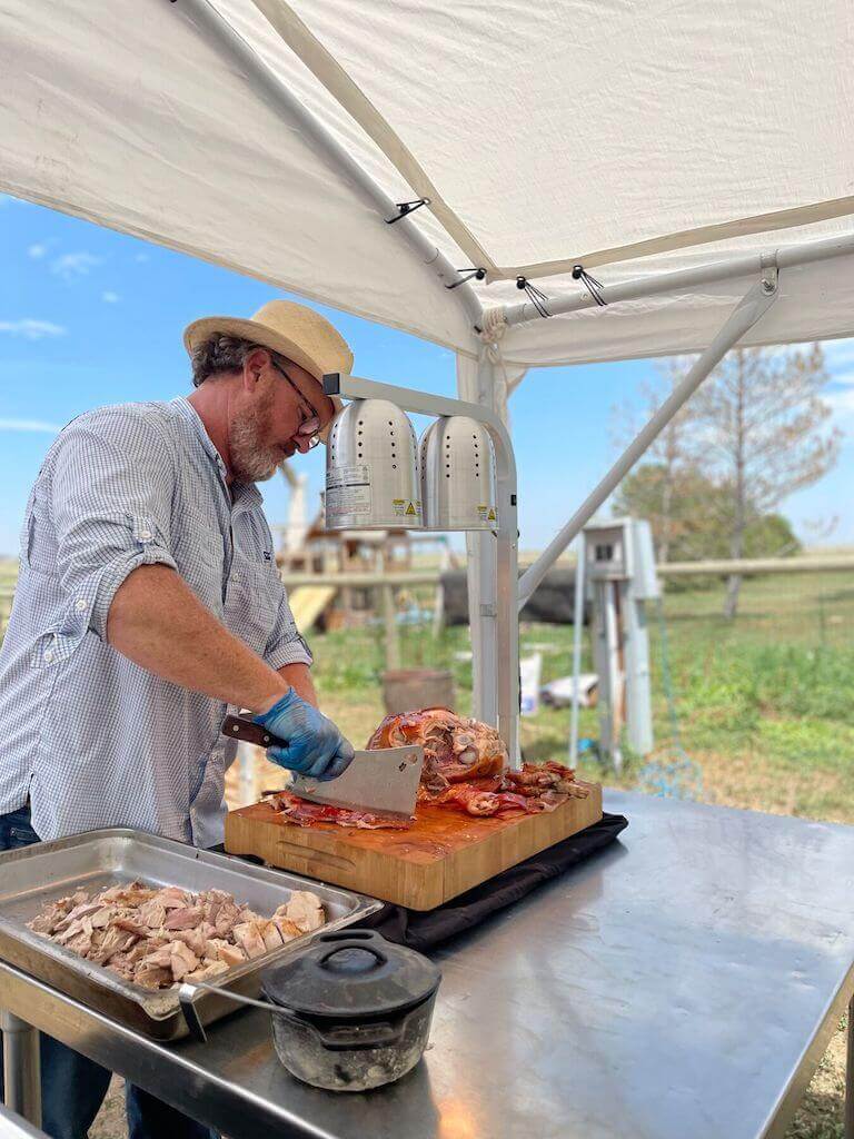 Chef Steven uses a cleaver to slice farm-raised pork.