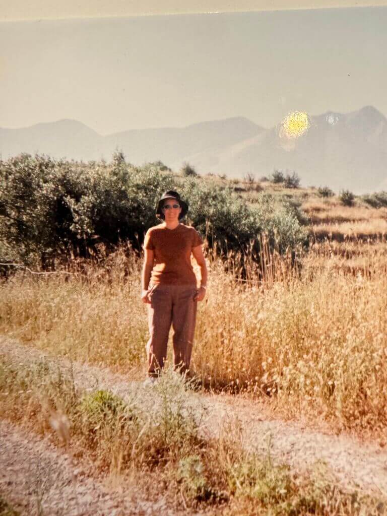 Lolita Sereleas stands in an olive grove in a village in Greece.