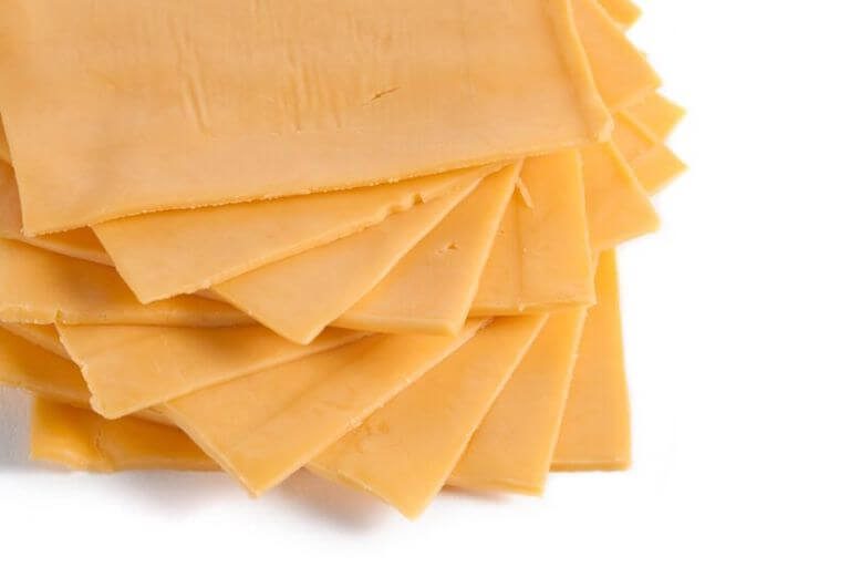 A stack of yellow slices of American cheese.