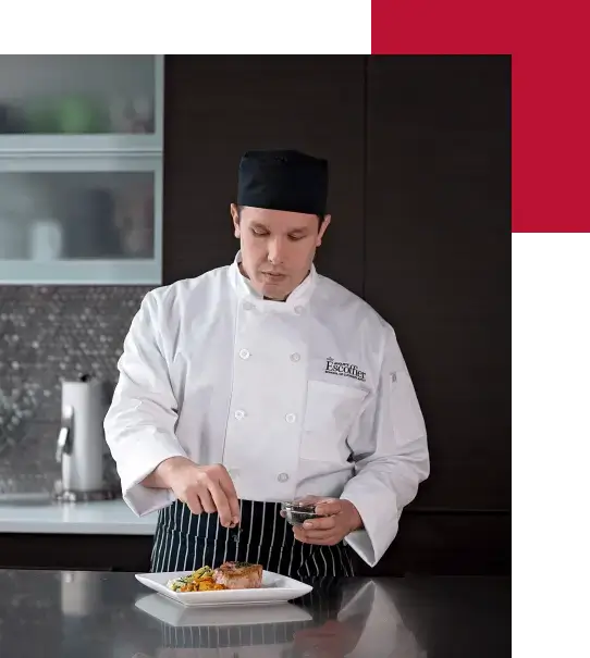 An online culinary arts program student garnishing a gourmet dish in his home kitchen