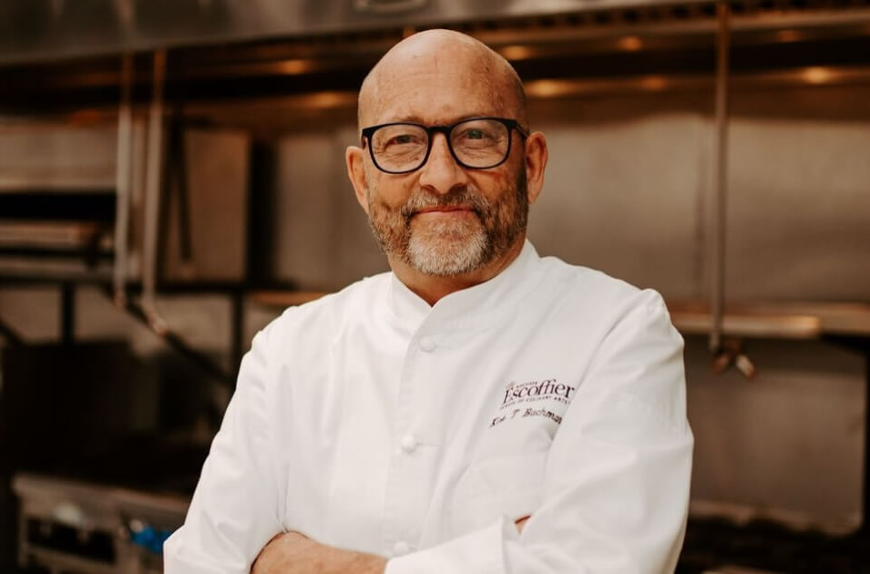 Chef Kirk Bachmann posing with arms crossed in Escoffier kitchen